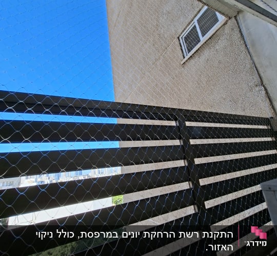 רשת יונים מותקנת על גדר ליד בניין